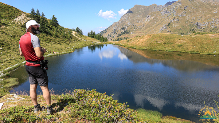 Trekking Milano Ayas Lago Literan prateria alpina nuvole e montagne ed escursionista